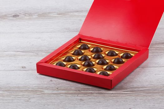 chocolate candy in a box isolated on wooden background