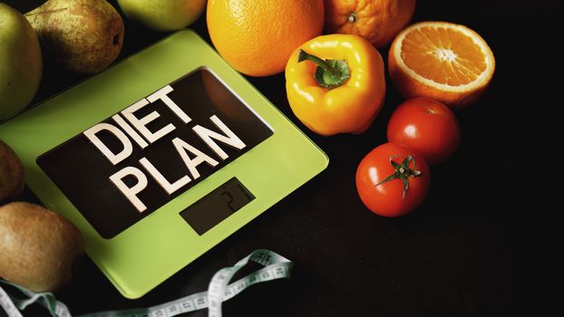 Concept diet. Healthy food, kitchen weight scale. Vegetables and fruits lettering Diet plan on black background