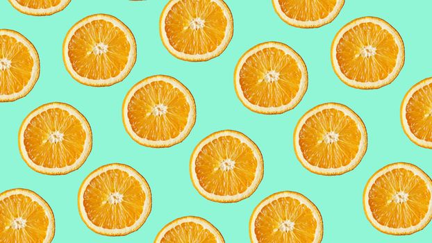 Colorful fruit pattern of fresh orange slices on modern blue background. From top view