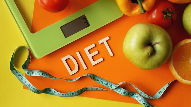 Concept diet. Healthy food, kitchen weight scale. Vegetables and fruits. Top view close-up on orange background