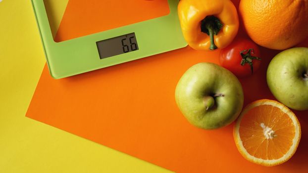 Concept diet. Healthy food, kitchen weight scale. Vegetables and fruits. Top view close-up on orange background