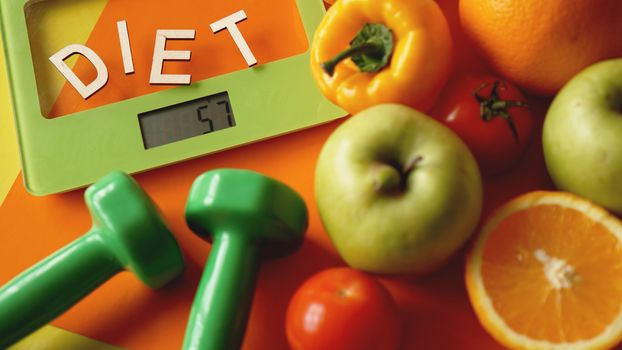 Concept diet. Healthy food, kitchen weight scale. Vegetables and fruits. Top view close-up on orange background