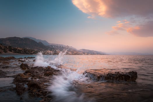 Beautiful dynamic seascape wit waves and spraying water, sunset.