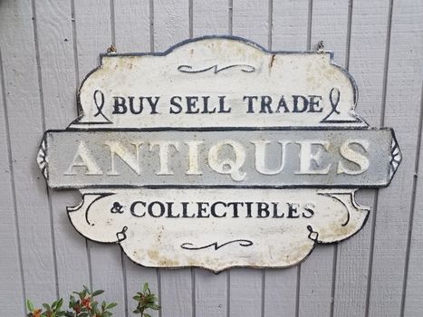 old buy sell trade antiques collectibles sign on grey wall