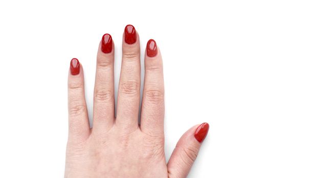 Beautiful female hand with fresh red manicure and nail isolated on white background