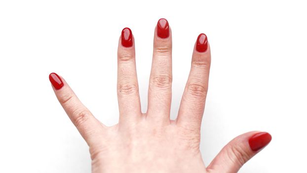 Beautiful female hand with fresh red manicure and nail isolated on white background