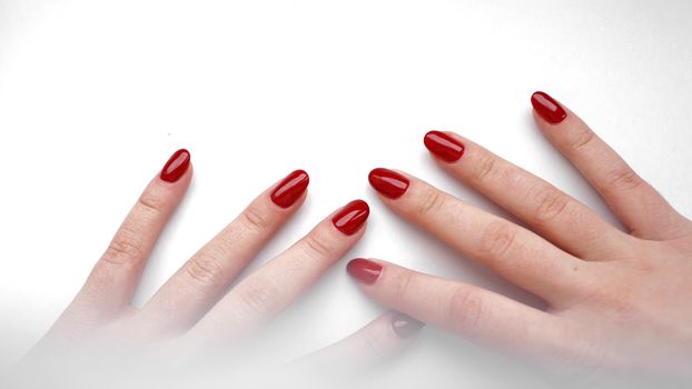 Beautiful female hands with red manicure and nail isolated on white background