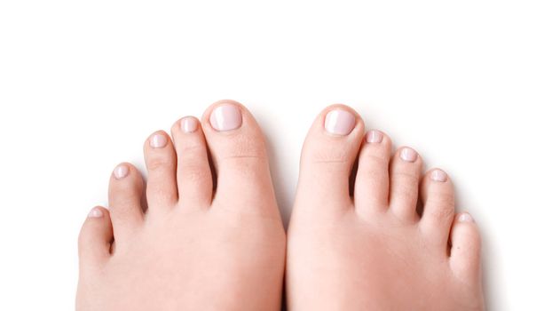 Woman feet with soft pink manicure isolated on white background