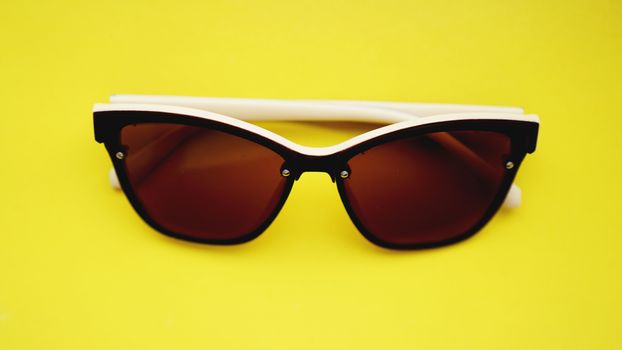 studio shot of sunglasses. summer is coming concept- yellow background