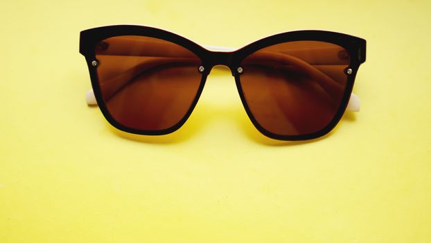 studio shot of sunglasses. summer is coming concept- yellow background