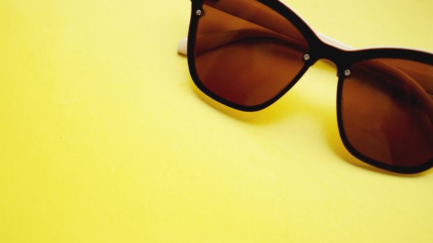 studio shot of sunglasses. summer is coming concept- yellow background