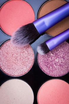 Snytethic makeup brushes with colorful makeup palette in the background