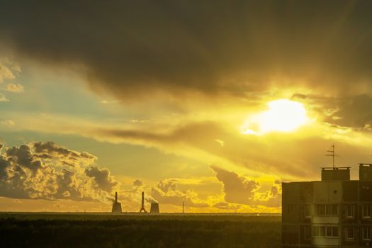 Sun's rays breaking through the thunderclouds on the outskirts of the city.