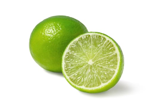 Fresh ripe limes, one whole and one half isolated on white background with shadow - image.