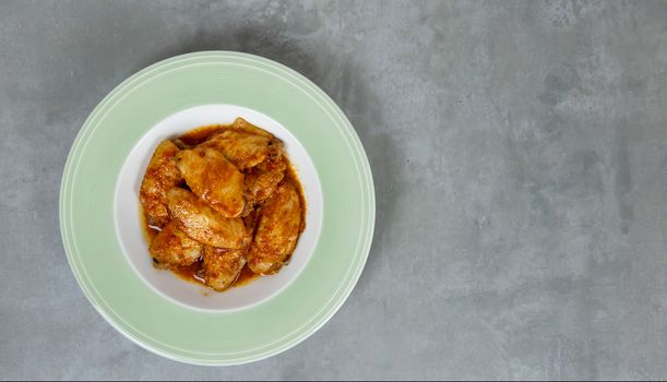 Baked chicken wings with spicy sauce. Food background with copy space. Top view