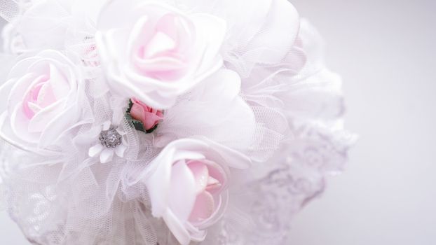 Wedding bouquet made of white roses on a blurred white background