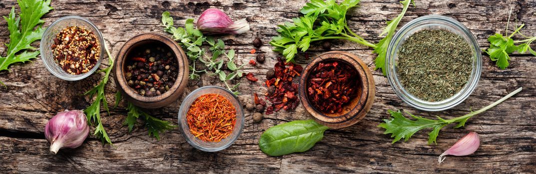 Herbs and spices on dark rustic kitchen table.Long banner