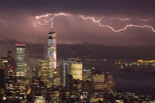 Artistic motion blured image of New York City skyline with lower Manhattan skyscrapers in lightning storm at night.