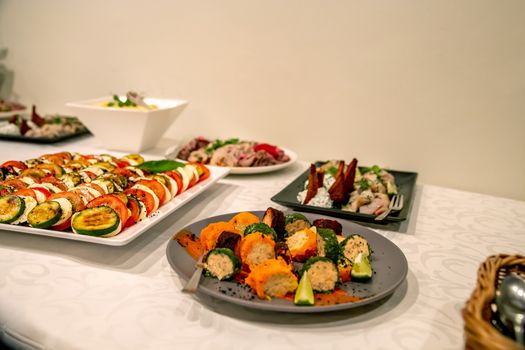 Vegetable dish and other snacks on the festive table in the restaurant. Various vegetable snacks and other appetizers on holiday table. Catering wedding table.