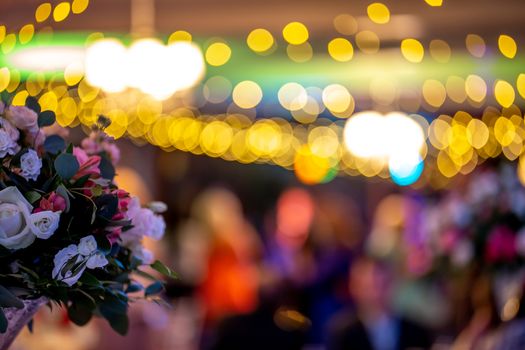 Bouquet of flowers on background of colorful bokeh light. Closeup of wedding flowers bouquet and blurred colorful lights in back.