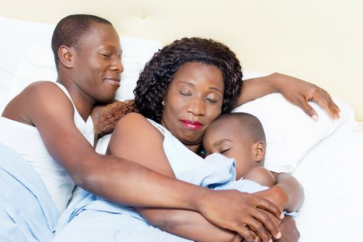this family lying in bed sleeping peacefully