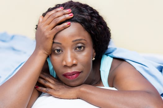 young woman in bed pensive hand on her forehead.