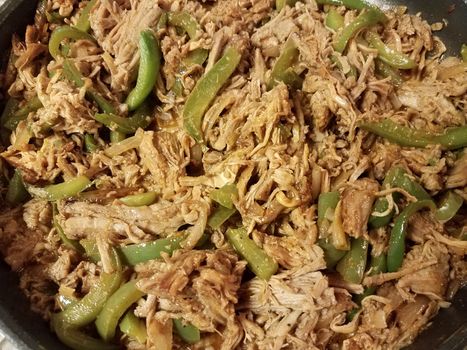 frying pan with pulled pork and green peppers on stove