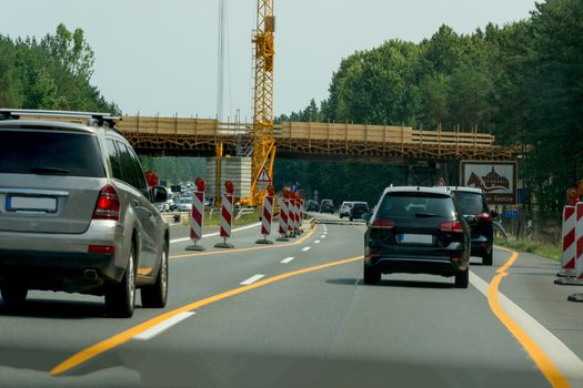 Various cars in a construction site area with construction crane on a german highway