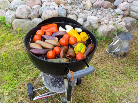 Cooking vegetables on a round grill outdoors in summer.