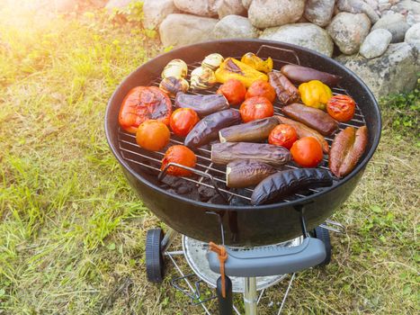 Cooking vegetables on a round grill outdoors in summer.