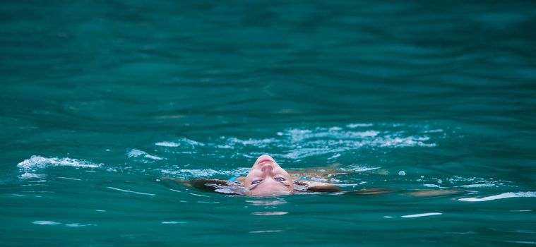 Girl relaxing floating in water of tropical sea