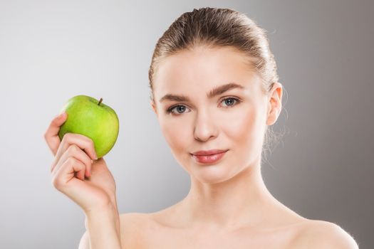 Young beautiful woman holding green apple