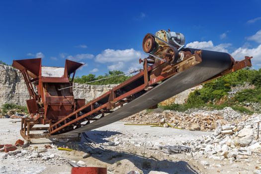 Old rusty stone crushing machine in abandoned quarry