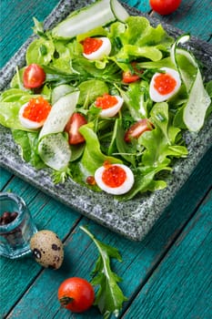 Healthy green salad.Spring salad with greens, cucumber, egg and red caviar.