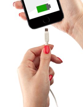 Smartphone in the hand of a woman. Connect the USB cable charger. Isolated on white background