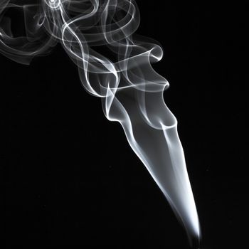 Abstract white smoke swirls over the black background