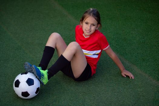 Little girl posing with football player luggage