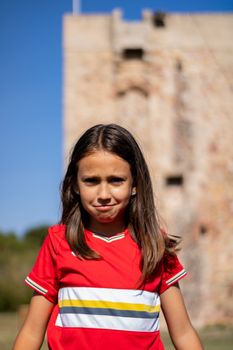 Little girl posing with football player luggage
