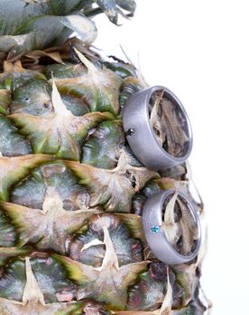 Wedding rings on a pineapple, isolated on a white background