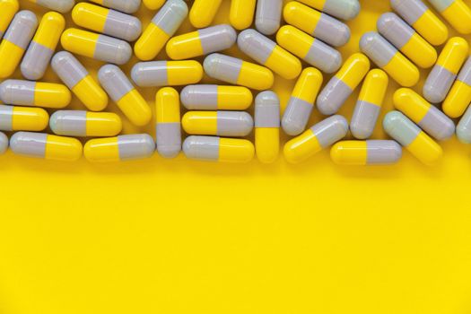 Capsule pills on yellow background