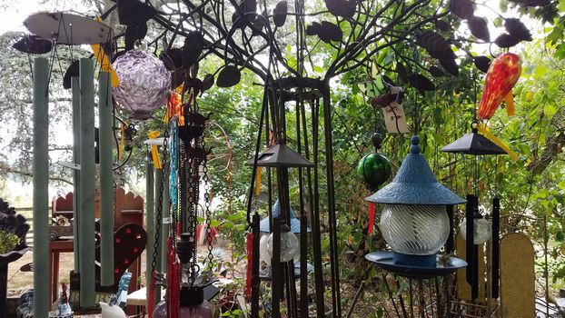 variety of metal windchimes or chimes hanging and tree