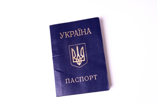 Blue Ukrainian passport isolated on white background. Passport is old and damaged a little bit. Stock photo of travel documents.