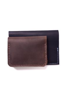 Handmade brown cardholder and black passport cover isolated on white background closeup. Stock photo of handmade luxury accessories.