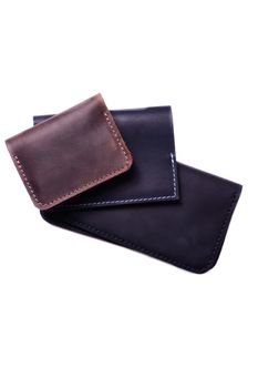 Handmade brown cardholder, black passport cover and purse isolated on white background closeup. Stock photo of handmade luxury accessories.