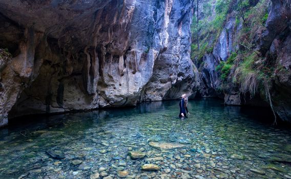 The start of the Mares Forest Creek Canyon.  A female looks up in awe admiring the canyon walls and limestone caves formed by the water and erosion.  The water has a high mineral content which gives it a unique colour.