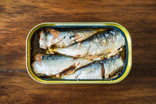 Canned sardines in olive oil on wood background