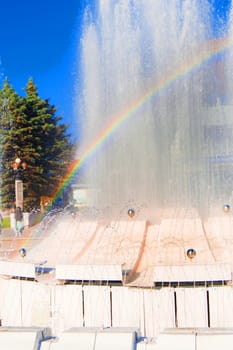 Blurred colorful rainbow on a background of splashing fountain on a Sunny summer day
