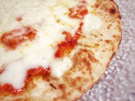 detail of a margherita pizza topped with tomato sauce and mozzarella cheese with crispy crust. Traditional Italian recipe. Typical Neapolitan cuisine