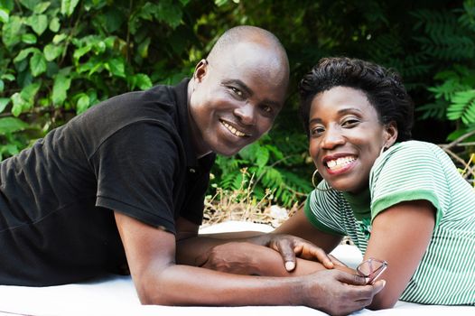 this smiling couple lying looking at the camera.