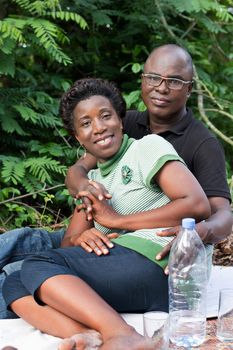 portrait of happy loving couple sitting in the forest. sitting on a white sheet young woman smiling with her fiance